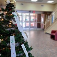 Christmas tree in common area with Angel tree names hanging from it