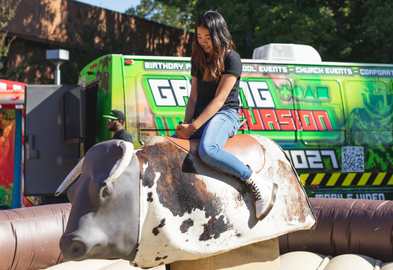 Student riding mechanical bull