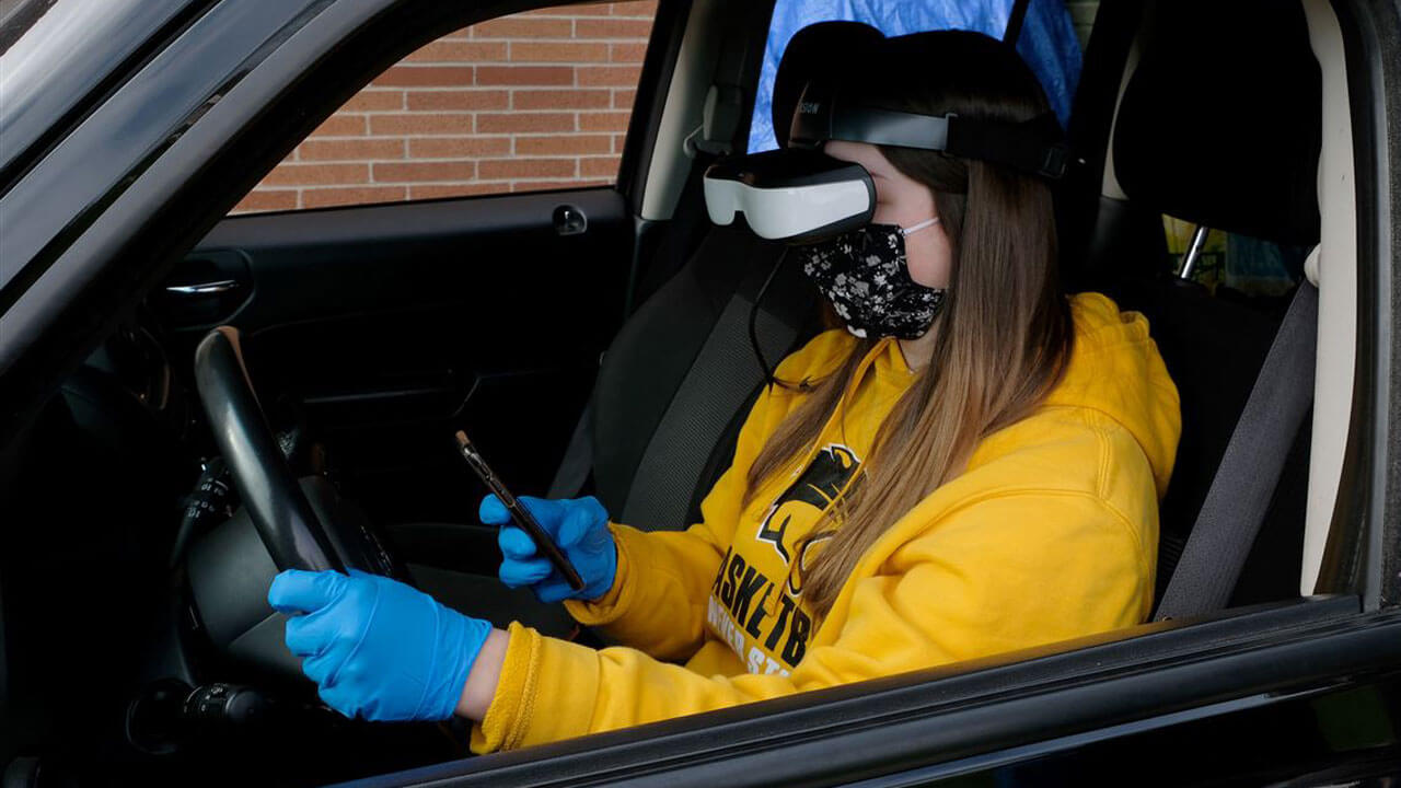 Student texting and driving while wearing VR headset