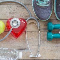 Various health and exercise items laying on wooden table