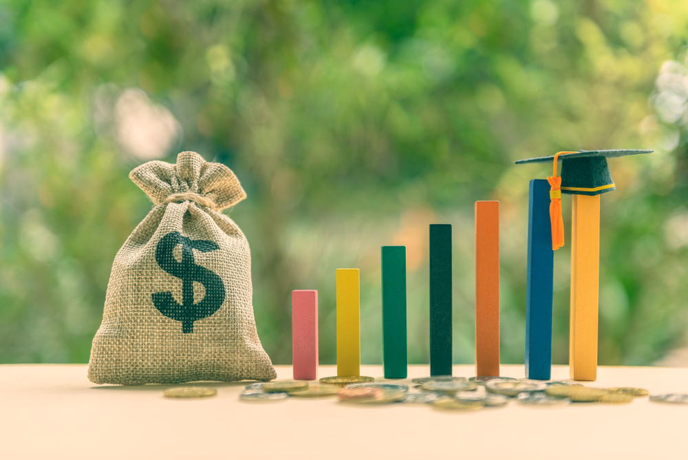 Moneybag and stylized bar graph lead toward commencement cap.