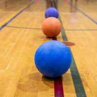 Dodgeballs lined up on gym floor