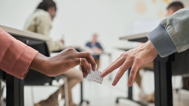 students passing a note during class