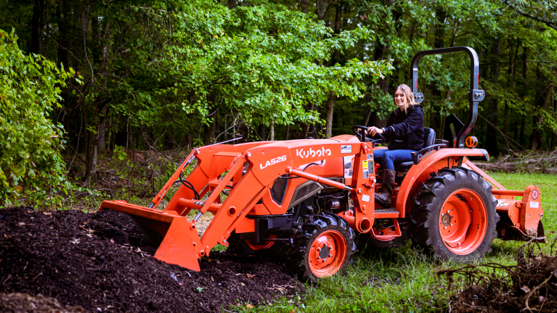 Sustainable Agriculture student driving a an orange tractor
