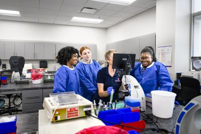 Medical Laboratory Technology Students With Instructor at microscope