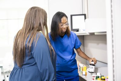 Two pharmacy students look at items on counter