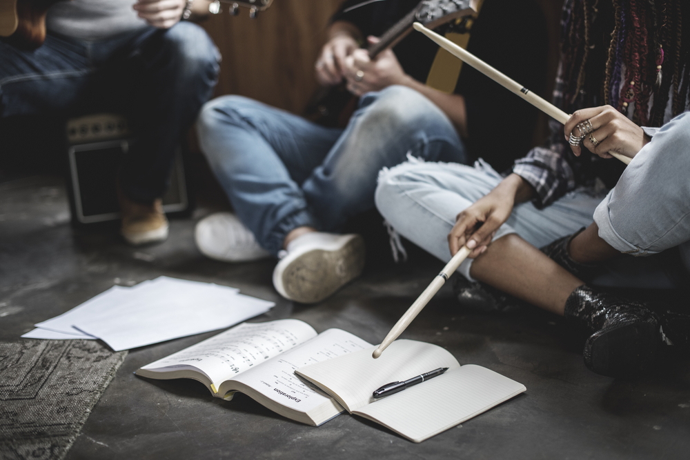 Group of teenagers holding instruments in casual music session