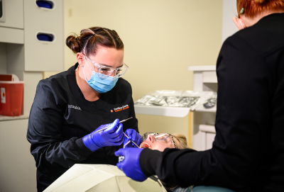 Dental professional working on a patient in a clinic setting.
