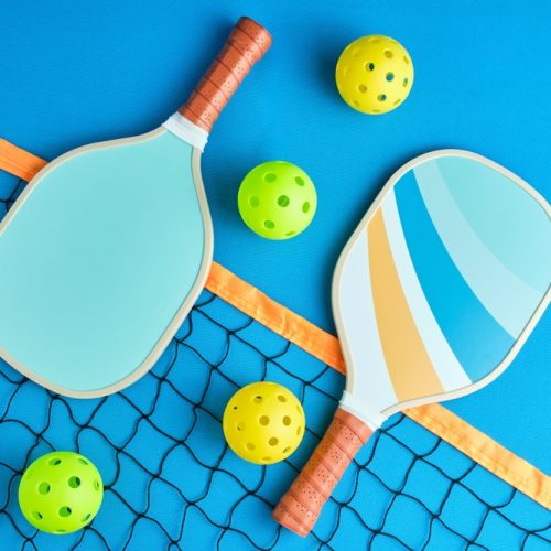 Two,Paddles,And,Four,Pickleball,Balls,On,Top,Of,A Pickleball paddles and balls